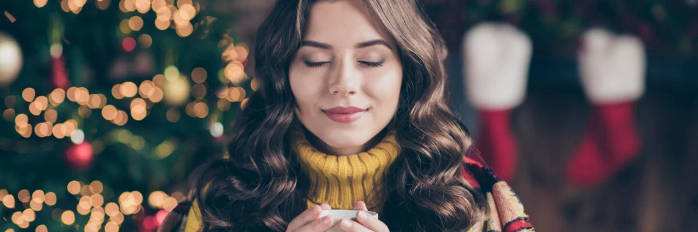 Mädchen mit Tasse vor Weihnachts-Setting.