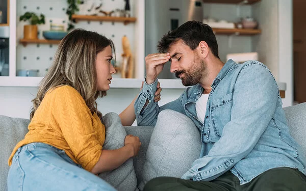 Über Gefühle reden: Ein Paar spricht über die psychische Gesundheit des Mannes im Wohnzimmer.